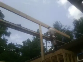 Carpenter setting a ridge beam over a new addition frame — Ice Dam Removal by Roofing Brothers in Garden Plain
