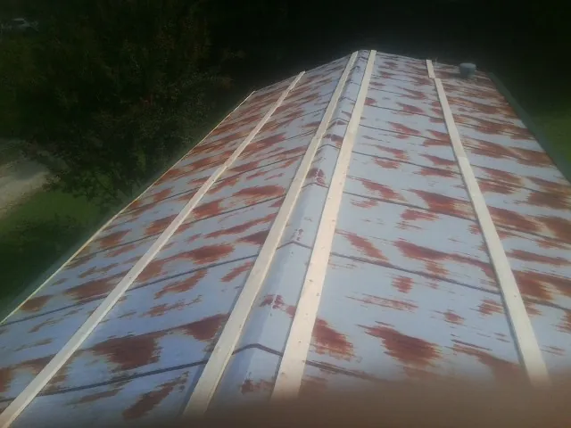 Rusted metal roof panels with new wood purlins before replacement — Storm Damage Roof Repair in Garden Plain by Roofing Brothers