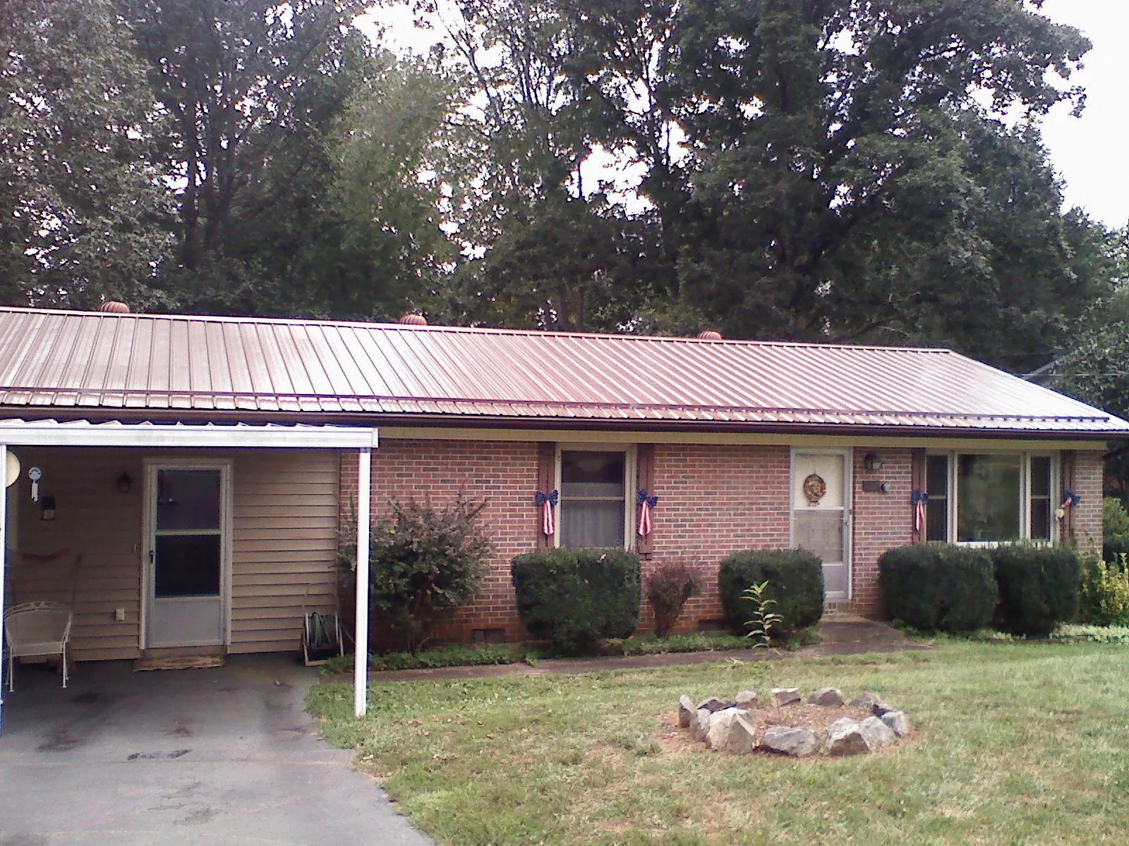 Bronze metal roof and carport on a brick ranch home — Roof Repair work by our crew in Garden Plain